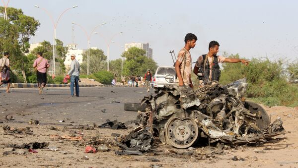 Fighters loyal to Yemen's President Abedrabbo Mansour Hadi look at the remains of a vehicle following a car bomb attack that targeted a convey of three senior south Yemeni officials in the Inma district, north of the the southern Yemeni city of Aden, on January 4, 2016. - Sputnik International
