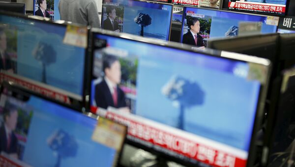 A sales assistant watches TV sets broadcasting a news report on North Korea's nuclear test, in Seoul, January 6, 2016 - Sputnik International