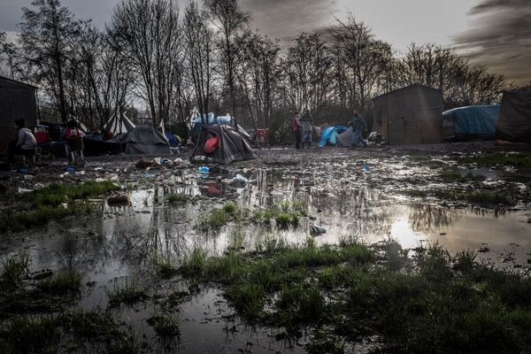 Dunkirk refugee camp surrounded by mud and puddles. Dunkirk refugee camp surrounded by mud and puddles. - Sputnik International