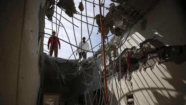 Men inspect a building damaged by a Saudi-led airstrike in Sanaa. - Sputnik International