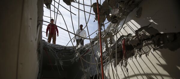 Men inspect a building damaged by a Saudi-led airstrike in Sanaa. Men inspect a building damaged by a Saudi-led airstrike in Sanaa. - Sputnik International