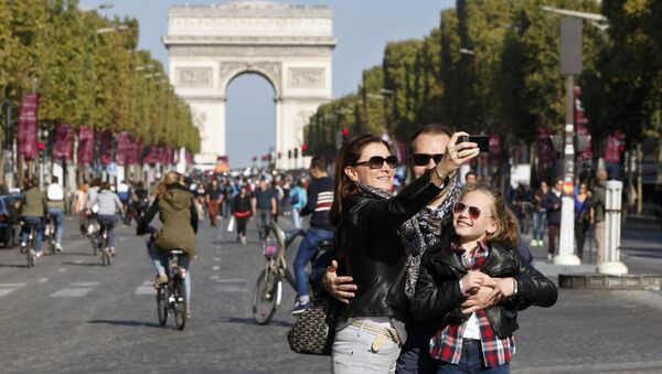 A familiy takes a selfie on the Champs-Elysees during the day without cars, in Paris, France, Sunday, Sept. 27, 2015. - Sputnik International