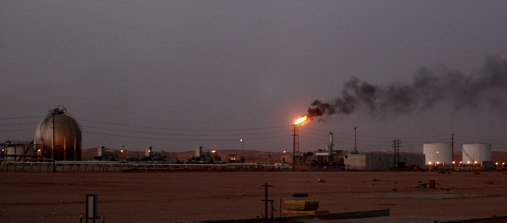 A flame from a Saudi Aramco (the national oil company) oil installation known as Pump 3 burns brightly during sunset in the Saudi Arabian desert near the oil-rich area Al-Khurais, 160 kms east of the capital Riyadh - Sputnik International, 1920, 17.03.2021