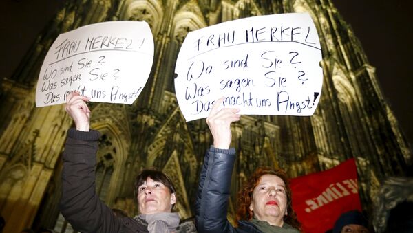 Women hold up placards that read Mrs. Merkel: Where are you? What are you saying? This worries us! during a protest in front of the Cologne Cathedral, Germany, January 5, 2016 - Sputnik International