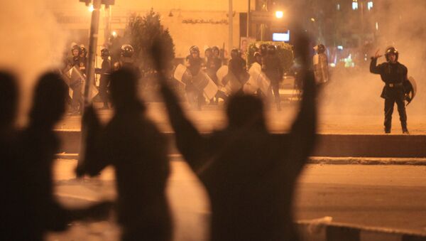 Egyptian protesters gesture as they clash with riot police at Cairo's landmark Tahrir Square on November 19, 2011, as Egyptian police fired rubber bullets and tear gas to break up a sit-in among whose organisers were people injured during the Arab Spring which overthrew veteran president Hosni Mubarak - Sputnik International