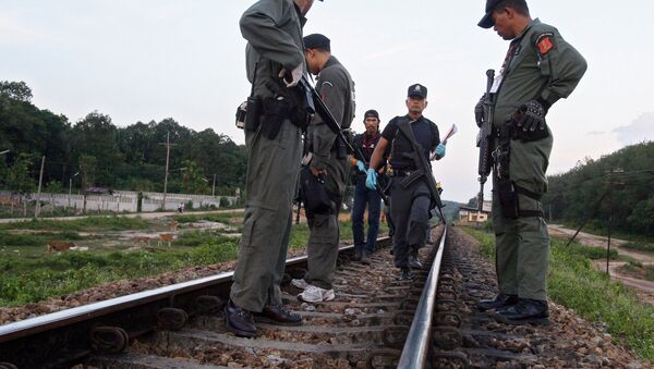 Thai police officers look for evidence on rail tracks in Thailand - Sputnik International