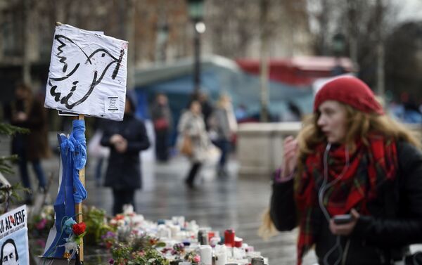 A picture taken on January 7, 2016 shows a woman standing in front of a makeshift memorial for the victims of Paris attacks at the Place de la Republique in Paris. - Sputnik International