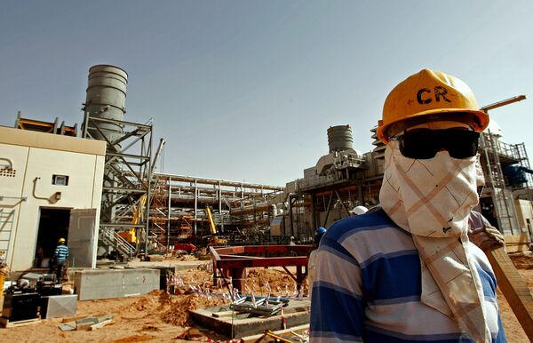 An Asian worker covers his face to protect it from the dust and the blazing sun at the site of Saudi Aramco's (the national oil company) Al-Khurais central oil processing facility under construction in the Saudi Arabian desert, 160 kms east of the capital Riyadh (File) - Sputnik International