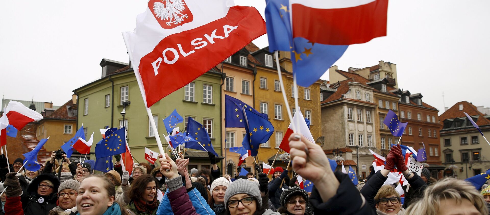 People hold EU and Polish flags as they gather during a pro-democracy demonstration at the Old Town in Warsaw, Poland January 9, 2016 - Sputnik International, 1920, 28.07.2016
