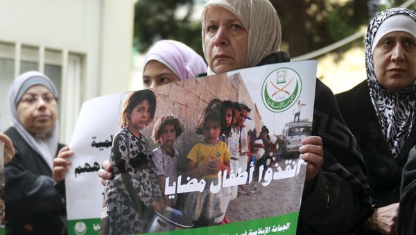 A woman holds a poster during a sit-in organized by the Sunni Al Jama'a al-Islamiya group, calling for the lifting of the siege off Madaya in front of the International Committee of the Red Cross (ICRC) in Beirut, Lebanon January 8, 2016 - Sputnik International