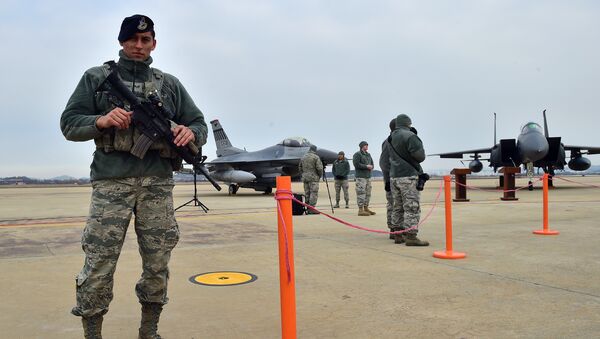 A US soldier (L) stands guard near a US F-16 fighter jet (C) and a South Korea F-15K fighter jet (R) before a press briefing on the flight by a US B-52 Stratofortress over South Korea at the Osan Air Base in Pyeongtaek, south of Seoul, on January 10, 2016 - Sputnik International