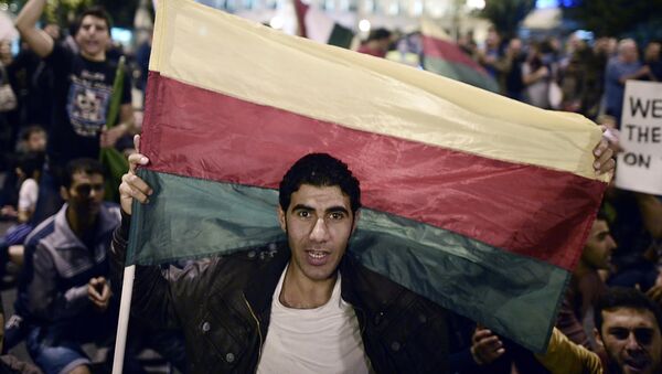 A man holds the flag of the Syrian Kurdish Democratic Union Party (PYD) - Sputnik International