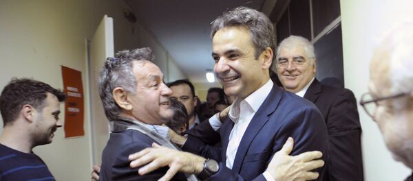 Kyriakos Mitsotakis (c-R), the new elected leader of Greece's conservative New Democracy party, hugs a supporter during his exit from his office in Athens, after winning the party elections, Greece, January 11, 2016 - Sputnik International