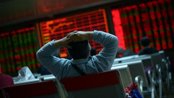 An investor looks at screens showing stock market movements at a securities company in Beijing on January 8, 2016 - Sputnik International