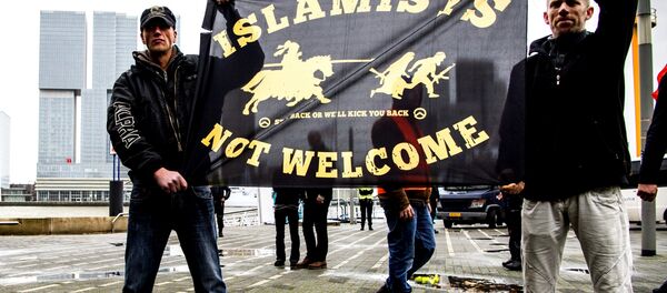 Supporters of Pegida (Patriotic Europeans Against the Islamisation of the West) hold a banner during a rally on November 29, 2015 in Rotterdam. Supporters of Pegida (Patriotic Europeans Against the Islamisation of the West) hold a banner during a rally on November 29, 2015 in Rotterdam. - Sputnik International
