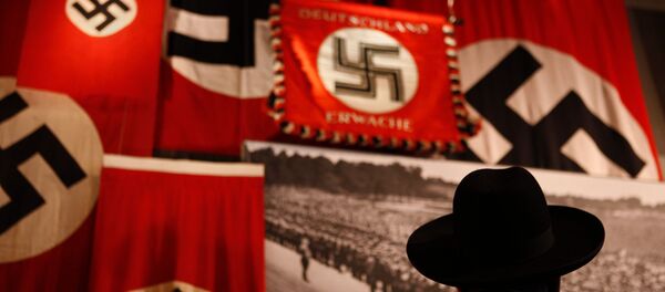A man looks at exhibit showing the Nazi flags. A man looks at exhibit showing the Nazi flags. - Sputnik International