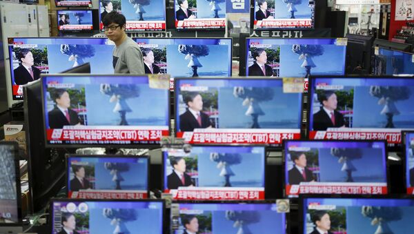 A sales assistant watches TV sets broadcasting a news report on North Korea's nuclear test, in Seoul, January 6, 2016 - Sputnik International