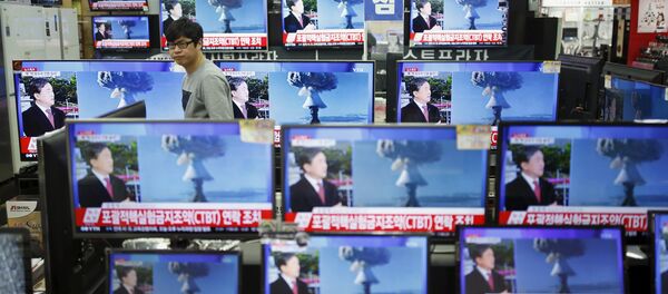 This file photo shows a sales assistant watches TV sets broadcasting a news report on North Korea's nuclear test, in Seoul, January 6, 2016 - Sputnik International