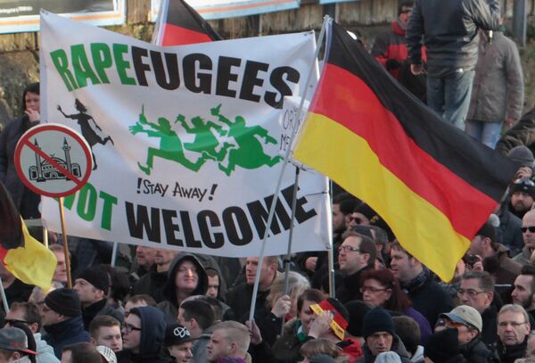 Right-wing demonstrators hold a sign Rapefugees not welcome - !Stay away! and a sign with a crossed out mosque as they march in Cologne, Germany Saturday Jan. 9, 2016 Right-wing demonstrators hold a sign Rapefugees not welcome - !Stay away! and a sign with a crossed out mosque as they march in Cologne, Germany Saturday Jan. 9, 2016 - Sputnik International