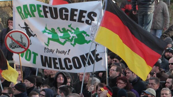 Right-wing demonstrators hold a sign Rapefugees not welcome - !Stay away! and a sign with a crossed out mosque as they march in Cologne, Germany Saturday Jan. 9, 2016 - Sputnik International