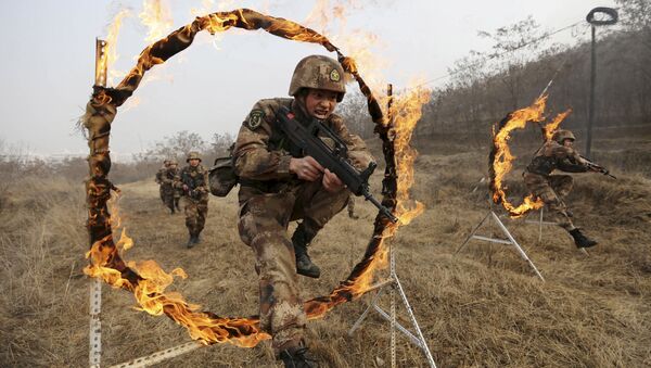 Soldiers of People's Liberation Army (PLA) Lanzhou Military Region jump through a burning obstacle during a training session at a military base in Tianshui, Gansu province, China, January 6, 2016 - Sputnik International