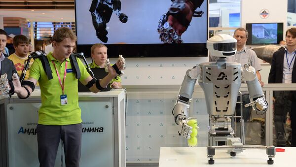 An employee of Androidnaya Teknika demonstrates a robot's operation at the V Innoprom International Industrial Exhibition in Yekaterinburg. File photo - Sputnik International