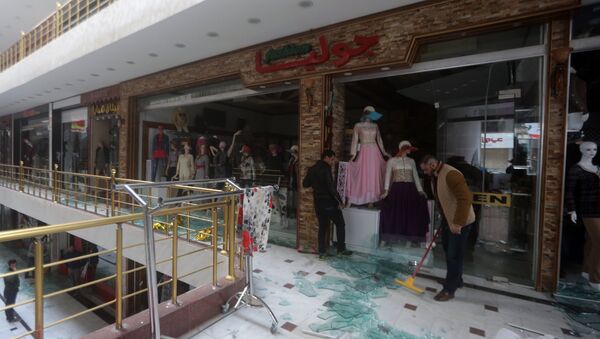 Iraqi men clean up the damage at the al-Jawaher mall in eastern Baghdad the day after a bomb attack on January 12, 2016 - Sputnik International