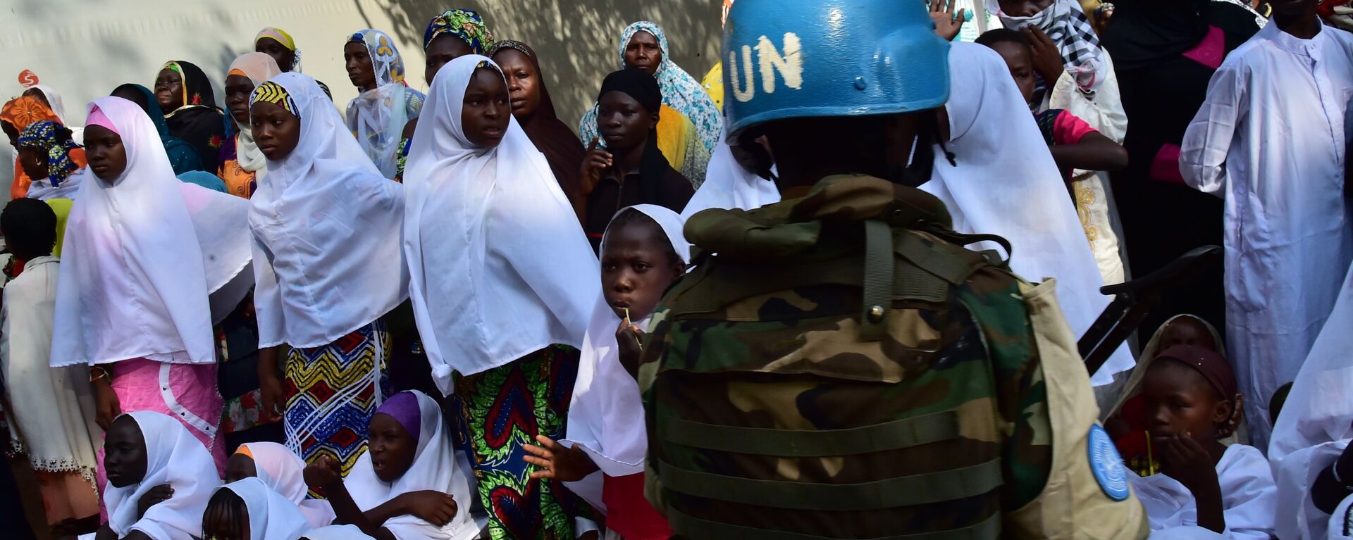 A soldier of the United Nations (UN) stands guard next to girls and women at the Bangui Mosque, Central African Republic, on November 30, 2015. - Sputnik International, 1920, 04.11.2022