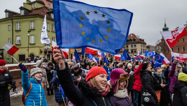 People wave European and Polish flags and sing the European anthem Ode to Joy as they take part in a flash mob to protest against a new media law in the center of Warsaw on January 9, 2016 - Sputnik International