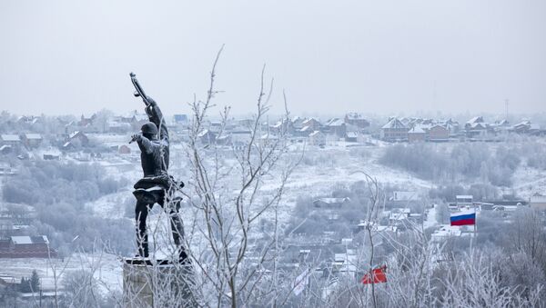 A monument to Red Army soldiers killed in action against Nazi Germany troops during World War II during the counteroffensive in 1941, at left, and Red and Russian national flags, right, are seen over houses covered with frost in the village of Peremilovo in Moscow region, Russia - Sputnik International