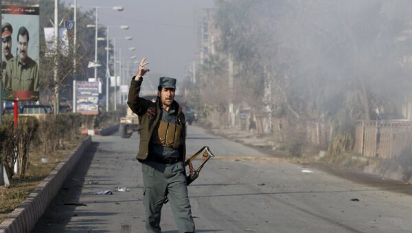 An Afghan policeman reacts as smoke billows during an attack near the Pakistani consulate in Jalalabad, Afghanistan January 13, 2016 - Sputnik International