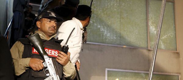 A paramilitary soldier stands guard at the ARY News offices as employees watch an attempt to remove shattered glass after a blast injured several people and caused property damage in Islamabad, Pakistan January 13, 2016. - Sputnik International