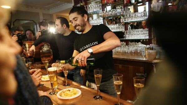 A barman serves champagne at the Carillon cafe, one of sites of the November 13 terror attacks in Paris, on January 13, 2016, on its reopening day. - Sputnik International