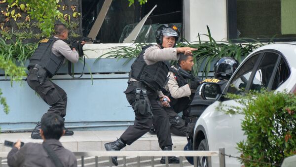 Indonesian police take position and aim their weapons as they pursue suspects outside a cafe after a series of blasts hit the Indonesia capital Jakarta on January 14, 2016 - Sputnik International
