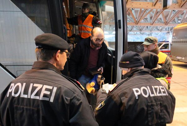 Austrian police officer check the identification documents of migrants before allowing them to get out a bus from Slovenia to cross the border from Slovenia into Austria, at a checkpoint at the Karawanks tunnel near Villach, Austria, Wednesday, Jan. 13, 2016. Austrian police officer check the identification documents of migrants before allowing them to get out a bus from Slovenia to cross the border from Slovenia into Austria, at a checkpoint at the Karawanks tunnel near Villach, Austria, Wednesday, Jan. 13, 2016. - Sputnik International