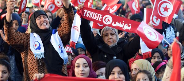 Tunisian women wave national flags and shout slogans on January 14, 2016, during a rally on Habib Bourguiba Avenue in Tunis to mark the fifth anniversary of the 2011 revolution. - Sputnik International