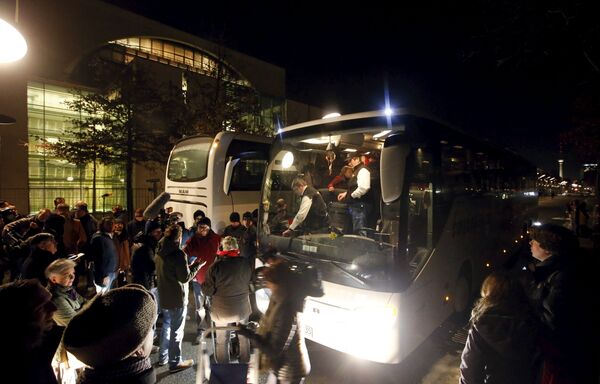 A bus (R) with refugees from the Bavarian town of Landshut is pictured after its arrival to the Chancellery building in Berlin, Germany, January 14, 2016 - Sputnik International