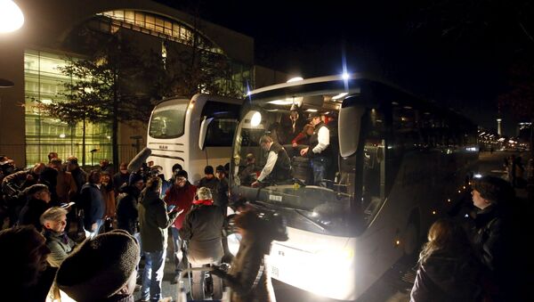 A bus (R) with refugees from the Bavarian town of Landshut is pictured after its arrival to the Chancellery building in Berlin, Germany, January 14, 2016 - Sputnik International