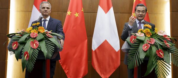 China's Foreign Minister Wang Yi (R) speaks next to Swiss Foreign Minister Didier Burkhalter at a joint news conference after a meeting at the Ministry of Foreign Affairs, in Beijing, China - Sputnik International
