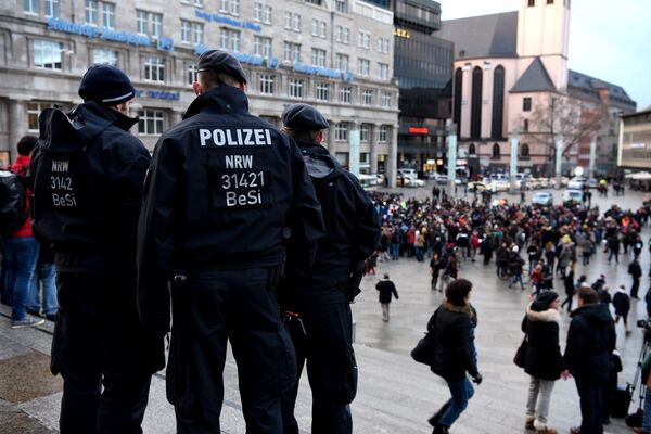 Policemen look on as refugees from Syria demonstrate against violence near the Cologne main train station in Cologne, western Germany on January 16, 2016 Policemen look on as refugees from Syria demonstrate against violence near the Cologne main train station in Cologne, western Germany on January 16, 2016 - Sputnik International