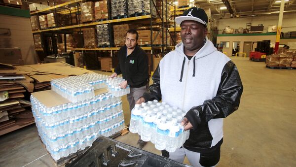 Anthony Fordham picks up bottled water from the Food Bank of Eastern Michigan to deliver to a school after elevated lead levels were found in the city's water in Flint, Michigan in this file photo from December 16, 2015 - Sputnik International