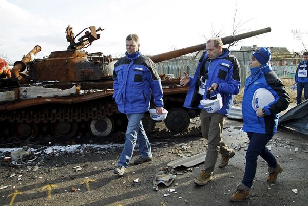Deputy Chief of the OSCE's Special Monitoring Mission to Ukraine Alexander Hug (L), with members of the mission, walks past a burnt tank as he inspects an area between DPR forces and Ukrainian government troops in the village of Kominternove north-east of the port city of Mariupol, Ukraine, January 15, 2016 Deputy Chief of the OSCE's Special Monitoring Mission to Ukraine Alexander Hug (L), with members of the mission, walks past a burnt tank as he inspects an area between DPR forces and Ukrainian government troops in the village of Kominternove north-east of the port city of Mariupol, Ukraine, January 15, 2016 - Sputnik International