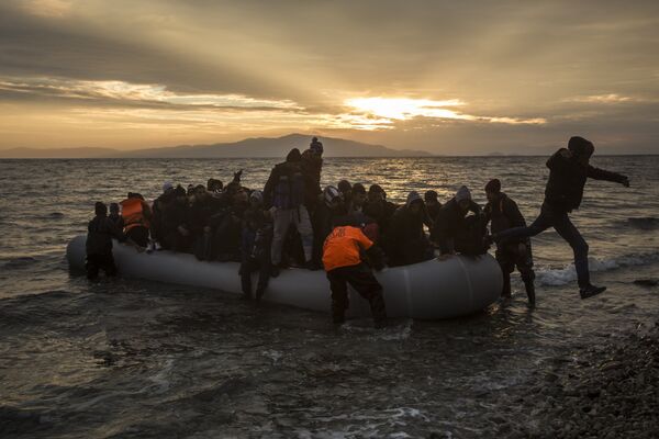 Refugees and migrants disembark on a beach after crossing a part of the Aegean sea from the Turkey's coast to the northeastern Greek island of Lesbos, on Sunday, Jan. 3, 2016 Refugees and migrants disembark on a beach after crossing a part of the Aegean sea from the Turkey's coast to the northeastern Greek island of Lesbos, on Sunday, Jan. 3, 2016 - Sputnik International