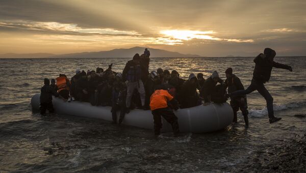 Refugees and migrants disembark on a beach after crossing a part of the Aegean sea from the Turkey's coast to the northeastern Greek island of Lesbos, on Sunday, Jan. 3, 2016 - Sputnik International