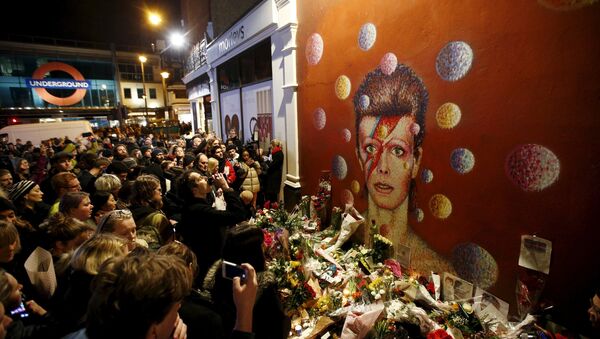 Fans stand by floral tributes at a mural of David Bowie in Brixton, south London, Britain January 11, 2016 - Sputnik International