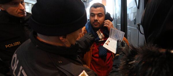 Austrian police officer check the identification documents of migrants before allowing them to get out a bus from Slovenia to cross the border from Slovenia into Austria, at a checkpoint at the Karawanks tunnel near Villach, Austria, Wednesday, Jan. 13, 2016 Austrian police officer check the identification documents of migrants before allowing them to get out a bus from Slovenia to cross the border from Slovenia into Austria, at a checkpoint at the Karawanks tunnel near Villach, Austria, Wednesday, Jan. 13, 2016 - Sputnik International