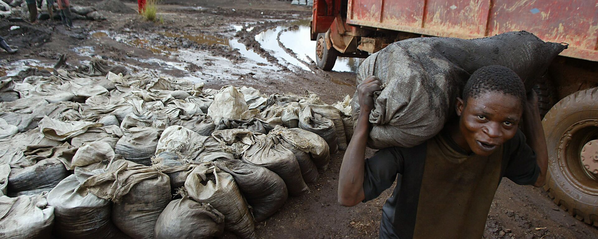 A young man carries wet cobalt on his back at the Shinkolobwe mine, about 35km from the town of Likasi in the Democratic Republic of the Congo, Saturday, 10 April 2004. - Sputnik International, 1920, 23.03.2021
