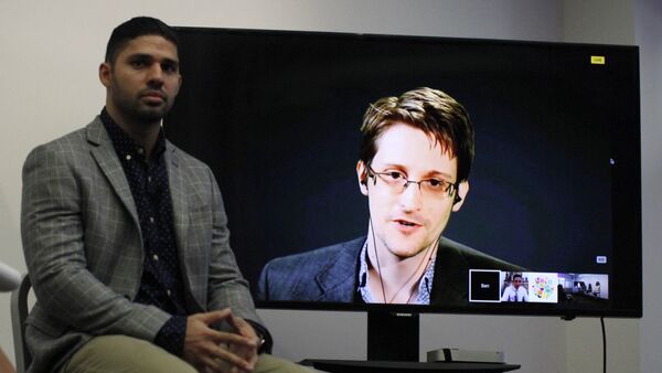 David Miranda (L) listens to American whistleblower Edward Snowden as he delivers remarks via video link from Moscow to attendees at a discussion regarding an International Treaty on the Right to Privacy, Protection Against Improper Surveillance and Protection of Whistleblowers in Manhattan, September 24, 2015 in New York - Sputnik International