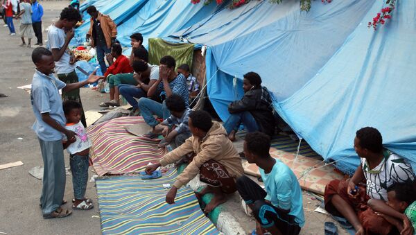 African migrants sit outside tents at a makeshift shelter on June 19, 2014, in the Yemeni capital Sanaa - Sputnik International