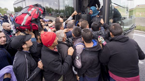 Migrants struggle to board a bus sent to pick them up on the closed highway A4 towards Vienna at the Austrian side of the border between Hungary and Austria on September 11, 2015 near Nickelsdorf, Austria - Sputnik International
